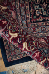 Curled edge vintage Indian Kashan rug, intact cream fringe, side cord, and plush pile.