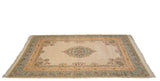 Angled view of a vintage Bulgarian carpet showing its floral medallion, Rococo borders, and ivory field.