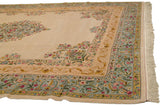 Angled view of the Bulgarian Kerman carpet's corner, showing the floral spandrels and Rococo borders.