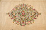 Tight weave and dense floral detail of the Kerman carpet's ornate powder blue center medallion.