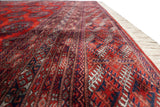 Exquisite geometric detail along the borders and plush pile of a vintage Turkmen design carpet.