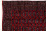 Corner detail of a vintage Pakistani rug with multiple geometric borders and intact white selvage.