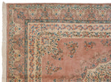 Vintage Indian Kerman rug corner: dusty rose field, scalloped edge, ivory border, blue floral vinery, white fringe.