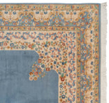 Corner detail of vintage Indian Kerman design rug: sky blue field, scalloped floral vinery, and fringe.