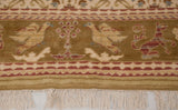 Close-up of the pictorial border with bird and lion motifs and the original hand-knotted fringe.