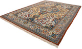 Vintage Indian carpet from a low angle, highlighting its elaborate floral field and rust-toned border.