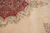 Raspberry red floral field with inwardly scalloped Rococo vinery on vintage Kerman rug.