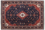 Elaborate cherry red spandrels and floral borders framing the navy blue field of a vintage Kashan carpet.