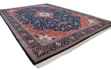 A traditional Kashan carpet's full layout viewed from an angle, showing the grand medallion and border system.