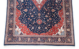 Elaborate corner spandrel and arabesque border in navy, red, and ivory on a vintage Indian carpet.