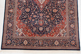 Vintage Indian Kashan rug corner, navy field, cherry red spandrel, intricate floral border, ivory fringe.