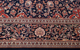 Intricate arabesque and floral border on a vintage Indian Kashan rug in navy and red.