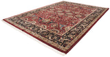 Vintage Agra carpet from a corner perspective, showing a red arabesque field and complex navy border.