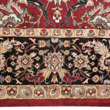 Detail of the Agra carpet's border showing lotus flowers and arabesque vinery on a black field.