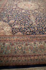 Detailed borders and dense floral field of a vintage Indian Ardebil carpet in navy, sea foam green, and blush.