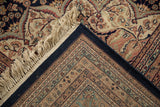 Folded corner of vintage Indian Ardebil carpet, revealing navy selvage, floral pile, and fringe.