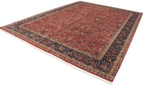 Vintage Agra carpet's navy border with scrolling vinery frames the brick red Samovar design field.