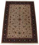 Vintage Agra carpet with scrolling vinery and a navy blue border, viewed from an angle.