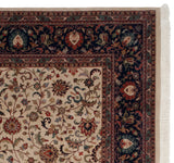 Corner detail of a hand-knotted Agra carpet with a navy lotus border and clean ivory fringe.