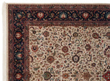 Vintage Agra carpet corner showing the detailed navy blue border and fine scrolling vinery on the ivory field.
