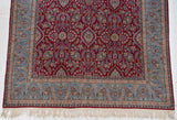 Corner of a Kerman rug with its diminutive floral arabesque border and clean ivory fringe.