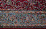 Vintage Kerman carpet's sky blue border with floral arabesques beside its dense cherry red field.