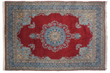 Vintage Kerman carpet with cherry red field, floral medallion, and blue patterned borders, 9'3