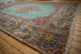 Elaborate Rococo-style floral border with cameo motifs on a plush, vintage Kerman rug.