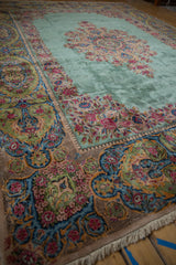 Intricate floral sprays within the wide cameo border of a plush vintage Kerman carpet.