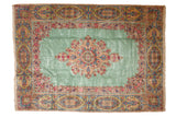 Vintage Kerman carpet with a Rococo style floral medallion on a pale ocean green field with elaborate rose borders.