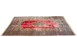 Low angle view of the vintage Kerman carpet highlighting the deep red pile's saturated color and sheen.