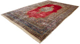 Full length angled view of a vintage Persian Kerman carpet with a red Rococo style medallion.
