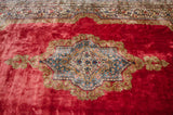 Rococo style center medallion with blue florals on the deep, plush cochineal red wool pile.