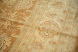 Plush pile texture of a vintage Indian Oushak rug with copper and beige floral patterns.