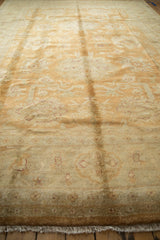 Fringed end of the Gold Wash Indian Oushak rug, showing soft beige and copper floral border.