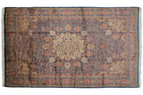 A fine Pakistani Ardebil carpet with a roundel medallion on an indigo blue and terracotta thousand-flower field.