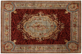 Indian Savonnerie carpet with a Rococo style medallion, red scrolling field, and slate blue borders.