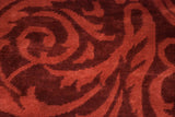 Tone-on-tone scrolling leaf design in cherry and wine red on the lustrous, full wool pile.