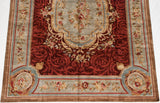 Floral cartouche and scrolling vinery on the slate blue and bronze border of a Savonnerie carpet.
