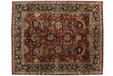 Vintage Indian Isfahan carpet with Safavid-era vinery on a cherry red field and a deep navy blue border.