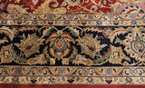 Detailed floral motifs and serrated leaves on the navy blue border of a vintage Isfahan carpet.