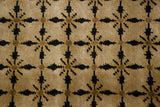 Close-up of the geometric lattice pattern in black on the dusty gold wool carpet.