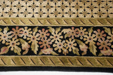 Hand-knotted detail of the Savonnerie carpet's floral border against the geometric field.
