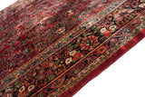 Intact cherry red side cord and detailed navy blue floral border on a vintage Sarouk carpet.