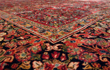 Low angle view of the dense, full pile and intricate floral corner of a vintage American Sarouk carpet.