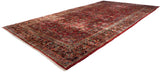 Angled view of a large vintage American Sarouk carpet with an intricate cherry red floral field.