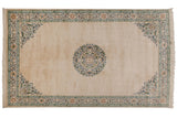 Japanese Peking carpet with a central medallion and spandrels in blue and green over an open ivory field.