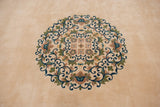 A close-up of the roundel center medallion with scrolling vines in blue, green, and mauve.