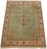 Sage green corner spandrel with dense scrolling vines and floral border motifs on the Peking rug.