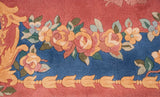 Close-up of the carpet's floral border with gold and raspberry roses on a sky blue band.